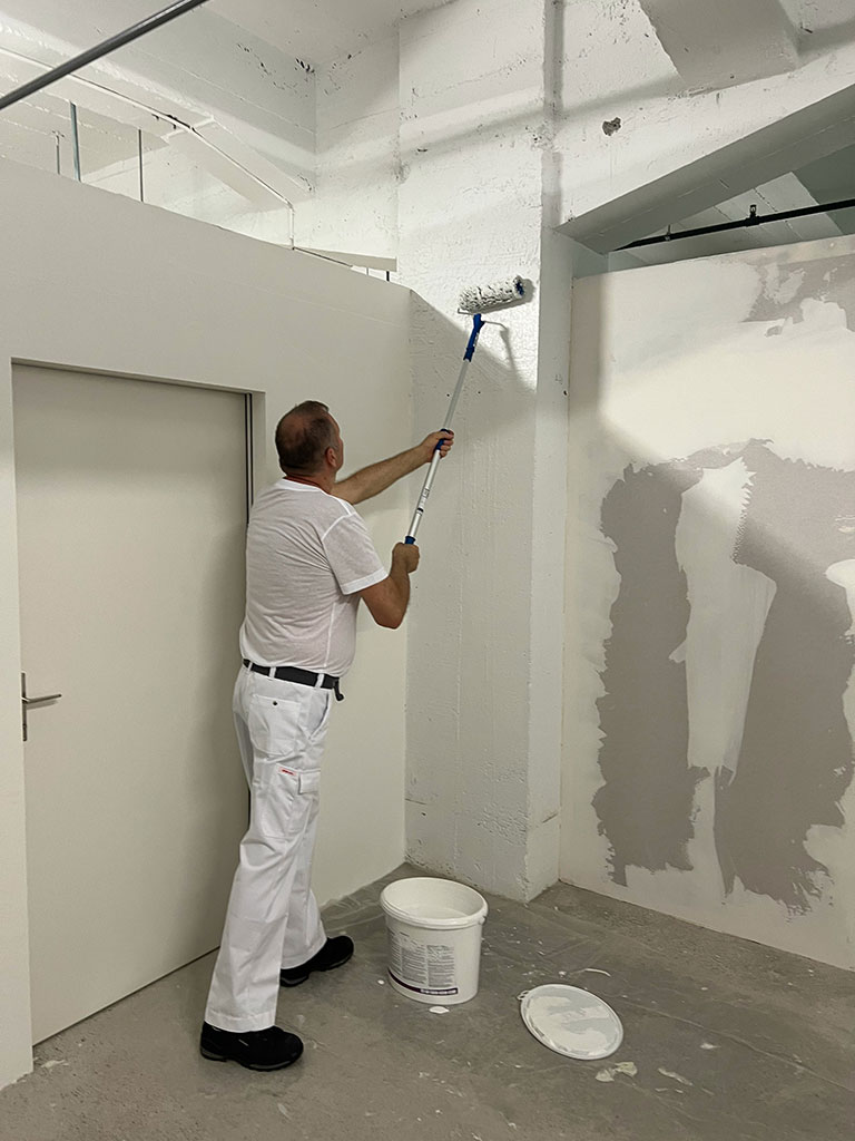 Malerarbeiten durchgeführt in Bern und Umgebung von der Firma MEGA Partner GmbH. Auf diesem Foto streicht einen Mahler eine Wand mit einem Farbroller. Malerarbeiten durchgeführt in Bern und Umgebung von der Firma MEGA Partner GmbH. Auf diesem Foto streicht einen Mahler eine Wand mit einem Farbroller.
